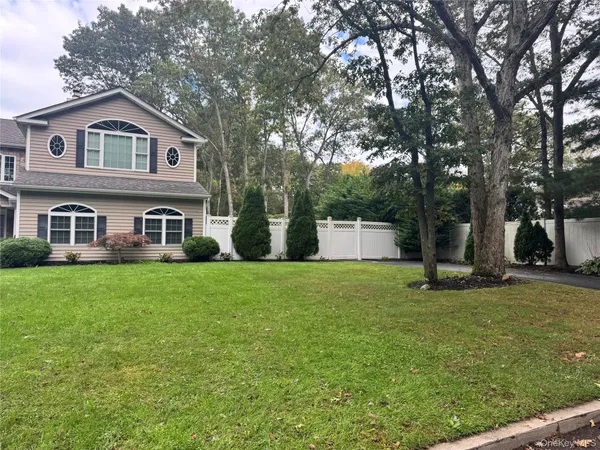 a front view of a house with a yard and trees