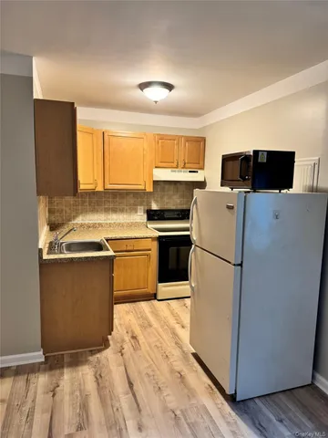a kitchen with a refrigerator and a stove top oven
