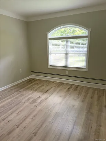 a view of a room with wooden floor and a window