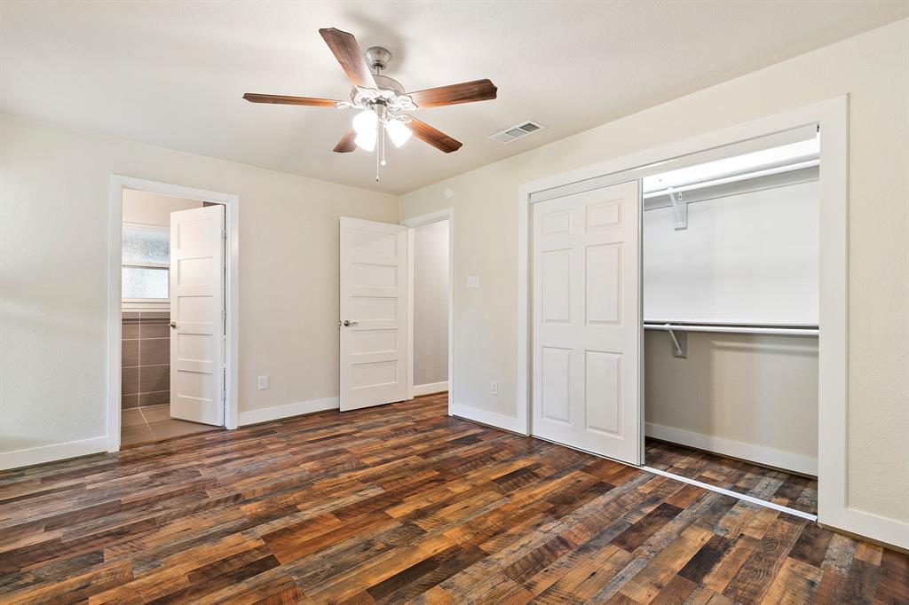 909 North Dove Road Grapevine, TX 76051 - Photo 17 of 30 Primary bedroom Room featuring multi-tone wood-finish flooring, white baseboards, and a ceiling fan with integrated lighting