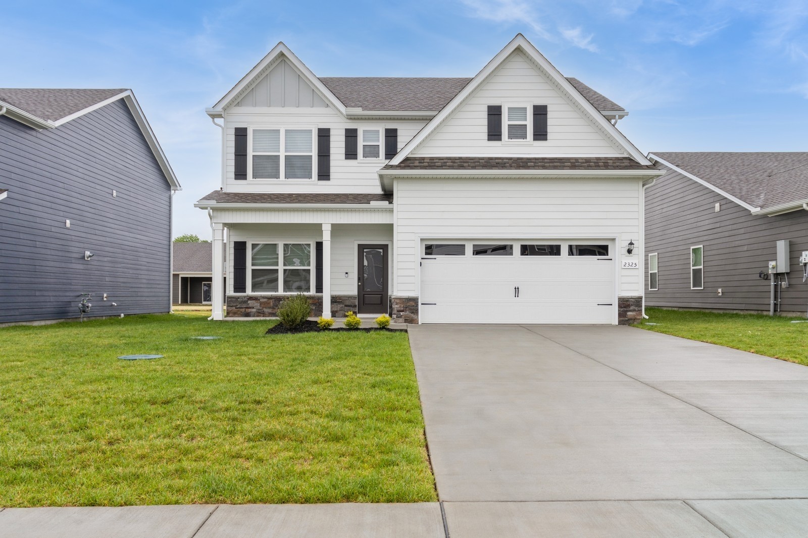 a view of a white house with a small yard and large window