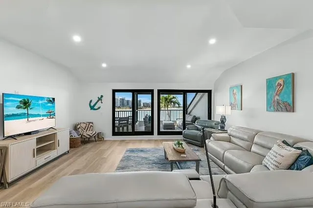 a living room with furniture large windows and a flat screen tv