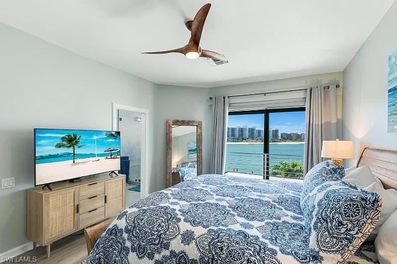 310 La Peninsula Boulevard, Unit 310 Naples, FL 34113 - Photo 13 of 27 a bedroom with a bed and a flat screen tv