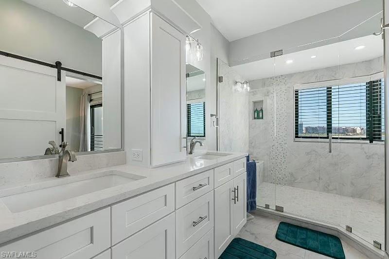 310 La Peninsula Boulevard, Unit 310 Naples, FL 34113 - Photo 16 of 27 a bathroom with a tub sink and mirror