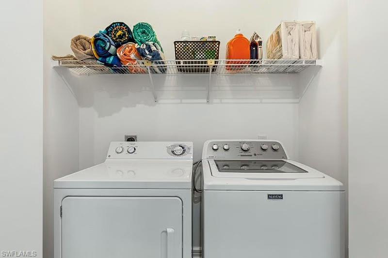 310 La Peninsula Boulevard, Unit 310 Naples, FL 34113 - Photo 19 of 27 a utility room with dryer and washer