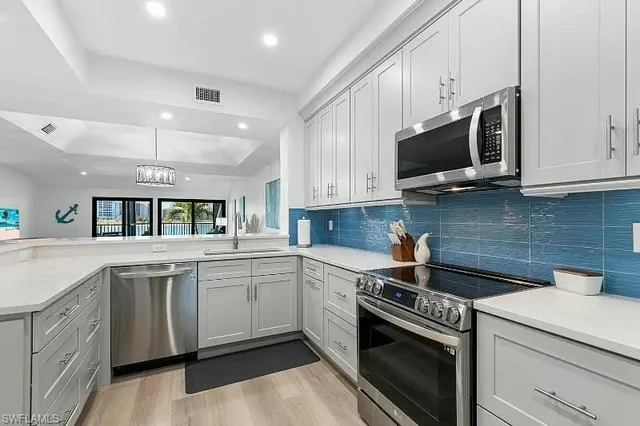 a kitchen with white cabinets stainless steel appliances and sink