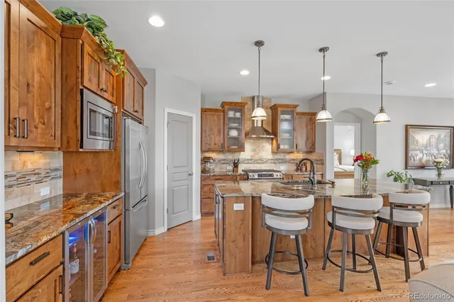 a kitchen with stainless steel appliances kitchen island a large island in the center and wooden cabinets