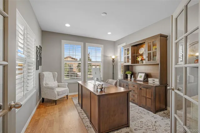 a living room with stainless steel appliances granite countertop furniture and a wooden floor