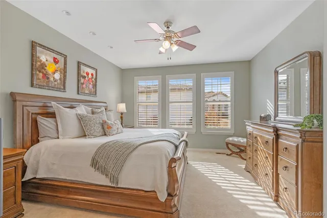 a spacious bedroom with a bed a couch and large window