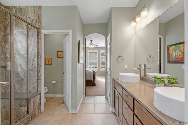 a en suite bathroom with a granite countertop sink mirror and shower