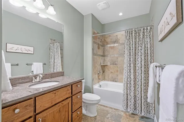 a bathroom with a granite countertop sink toilet and shower