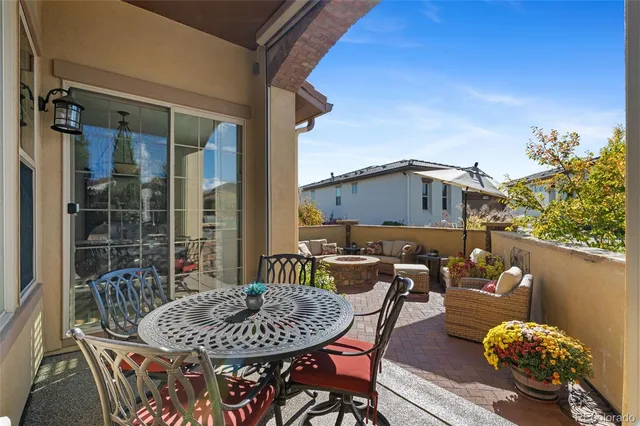 a patio with a table and chairs under an umbrella