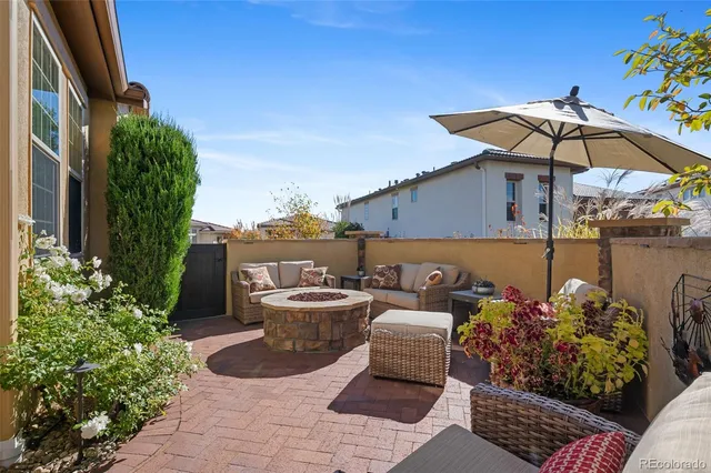 a view of a patio with couches and table and chairs under an umbrella