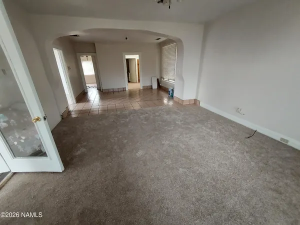 an empty room with a fireplace and mirrors