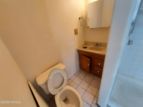 a bathroom with a granite countertop toilet sink and mirror