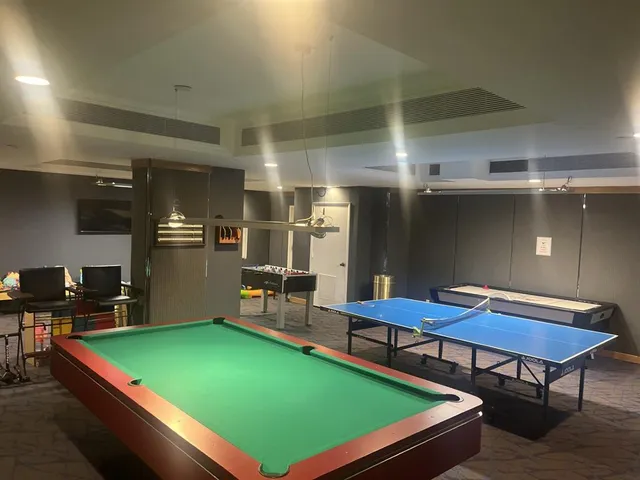 a room with chairs pool table and chairs