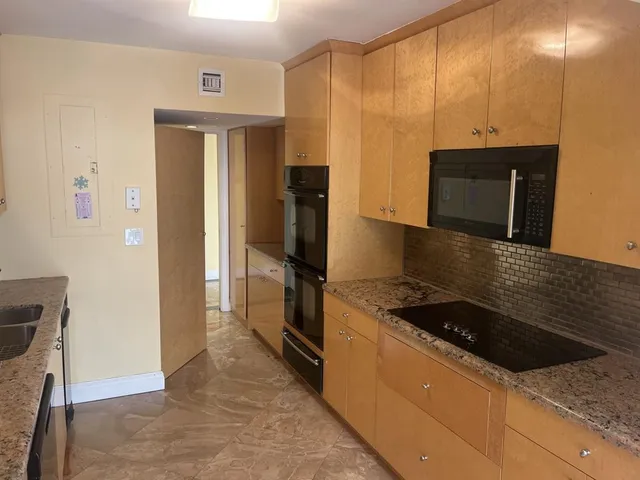 a kitchen with granite countertop a refrigerator and a stove