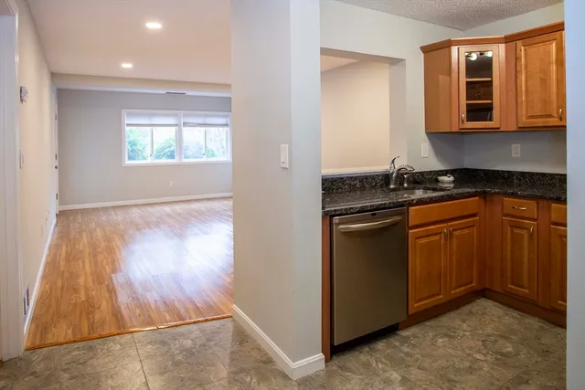 a kitchen with granite countertop wooden cabinets and a stove top oven