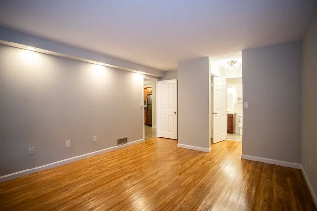 a view of an empty room with wooden floor
