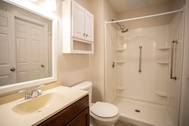 a bathroom with a sink a toilet and shower