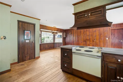 a kitchen with a stove and wooden cabinets