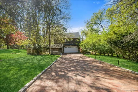 a front view of a house with a yard and garden