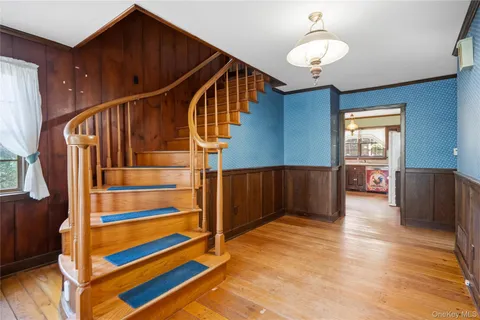 a view of entryway and hall with wooden floor