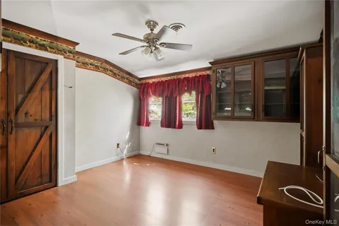 a view of empty room with window and ceiling fan
