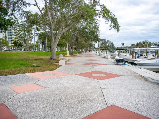 a room with lots of dining table chairs and couches next to a large window