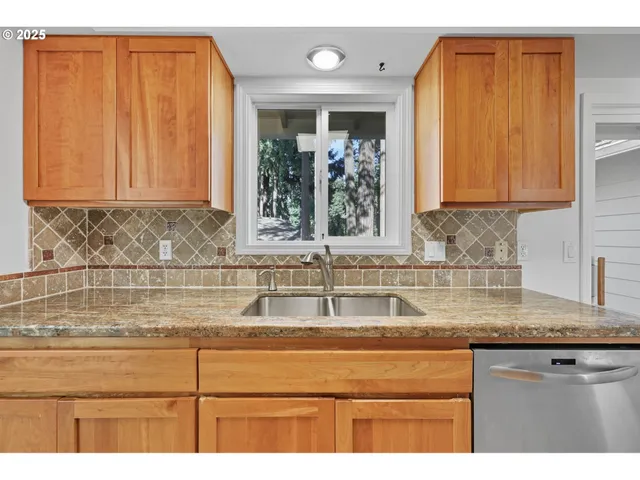 a kitchen with granite countertop cabinets sink and window