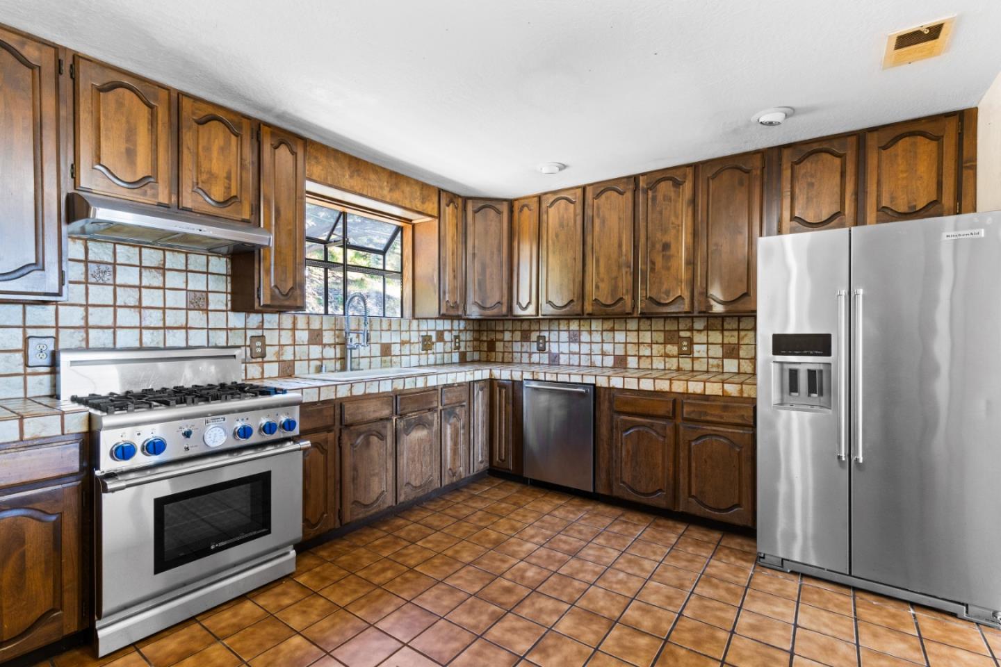 720 Alta Vista Drive Pacifica, CA 94044 - Photo 13 of 40 a kitchen with stainless steel appliances granite countertop a stove top oven a refrigerator and a sink