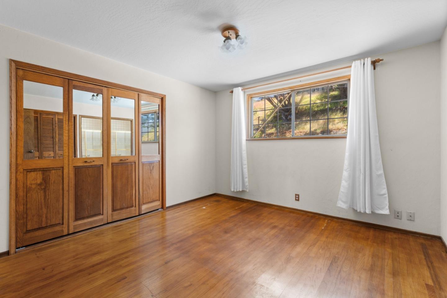 720 Alta Vista Drive Pacifica, CA 94044 - Photo 15 of 40 an empty room with wooden floor and windows