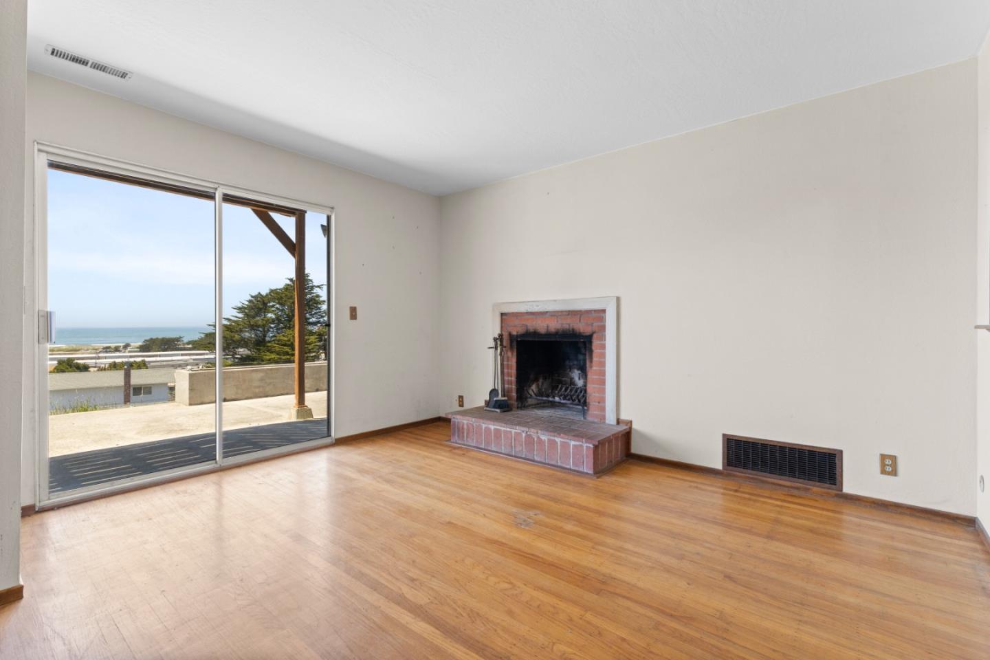 720 Alta Vista Drive Pacifica, CA 94044 - Photo 9 of 40 a view of empty room with wooden floor and fireplace