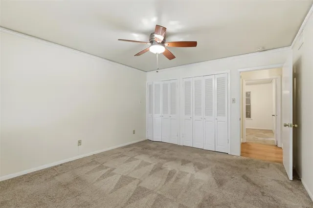 an empty room with closet and a chandelier fan
