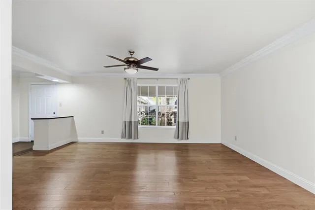 a view of wooden floor and a chandelier fan in a room