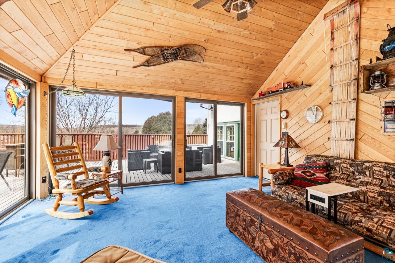 2170 Lester River Road Duluth, MN 55804 - Photo 38 of 66 Sunroom featuring carpet, wood walls, and a vaulted wooden ceiling