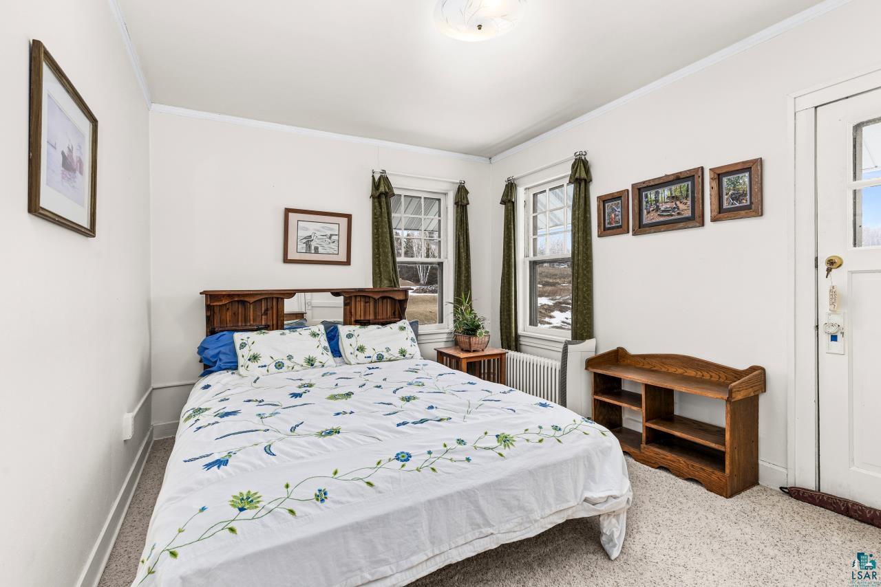 2170 Lester River Road Duluth, MN 55804 - Photo 50 of 66 Bedroom featuring light carpet, ornamental molding, and radiator