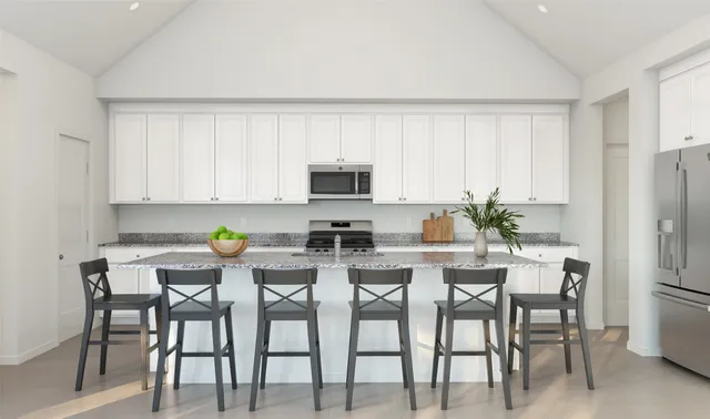 a kitchen with stainless steel appliances a dining table chairs and a refrigerator