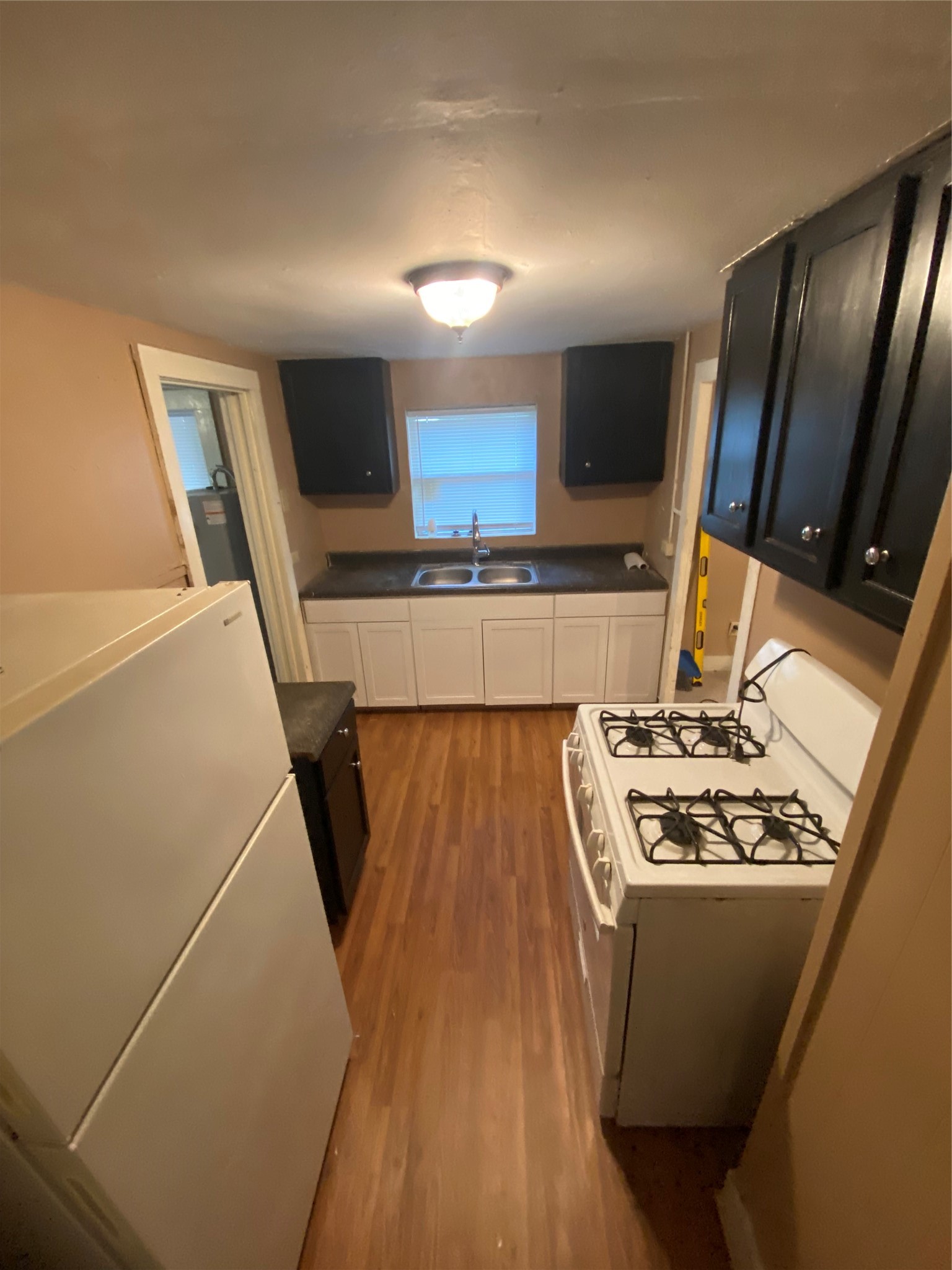 110 Peeples Street Navasota, TX 77868 - Photo 3 of 7 a kitchen with microwave a sink and a stove