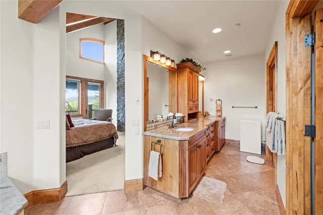 a en suite bathroom with a double vanity sink a mirror and a bathtub