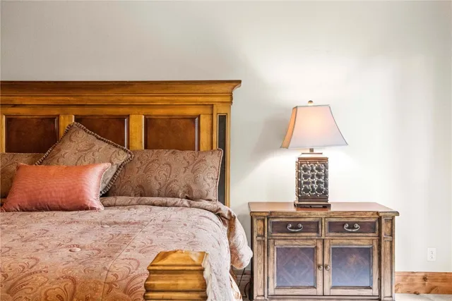 a bedroom with a bed and a lamp on dresser