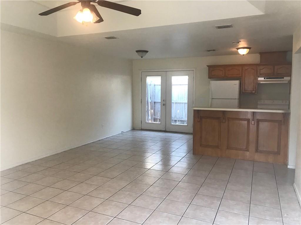 901 English Avenue, Unit 3 Edinburg, TX 78541 - Photo 2 of 9 an empty room with kitchen and chandelier fan