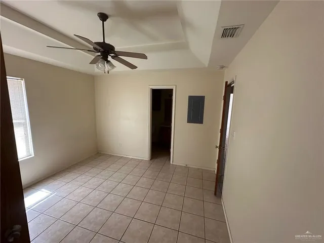 a view of a livingroom with a chandelier fan and wooden floor