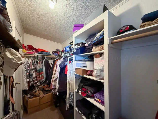 a view of walk in closet with clothes