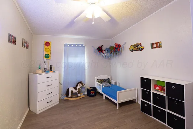 a view of a bedroom with baby crib and lounge chair