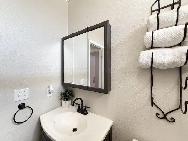a bathroom with a granite countertop sink and mirror
