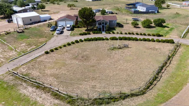 an aerial view of a house with a yard and lake