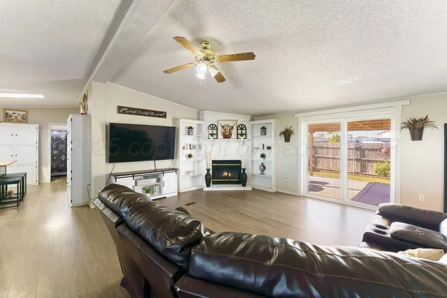 a living room with furniture a flat screen tv and a large window