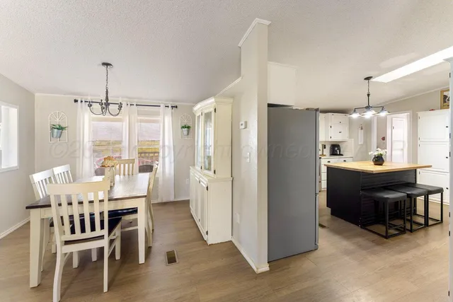 a kitchen with refrigerator cabinets dining table and chairs