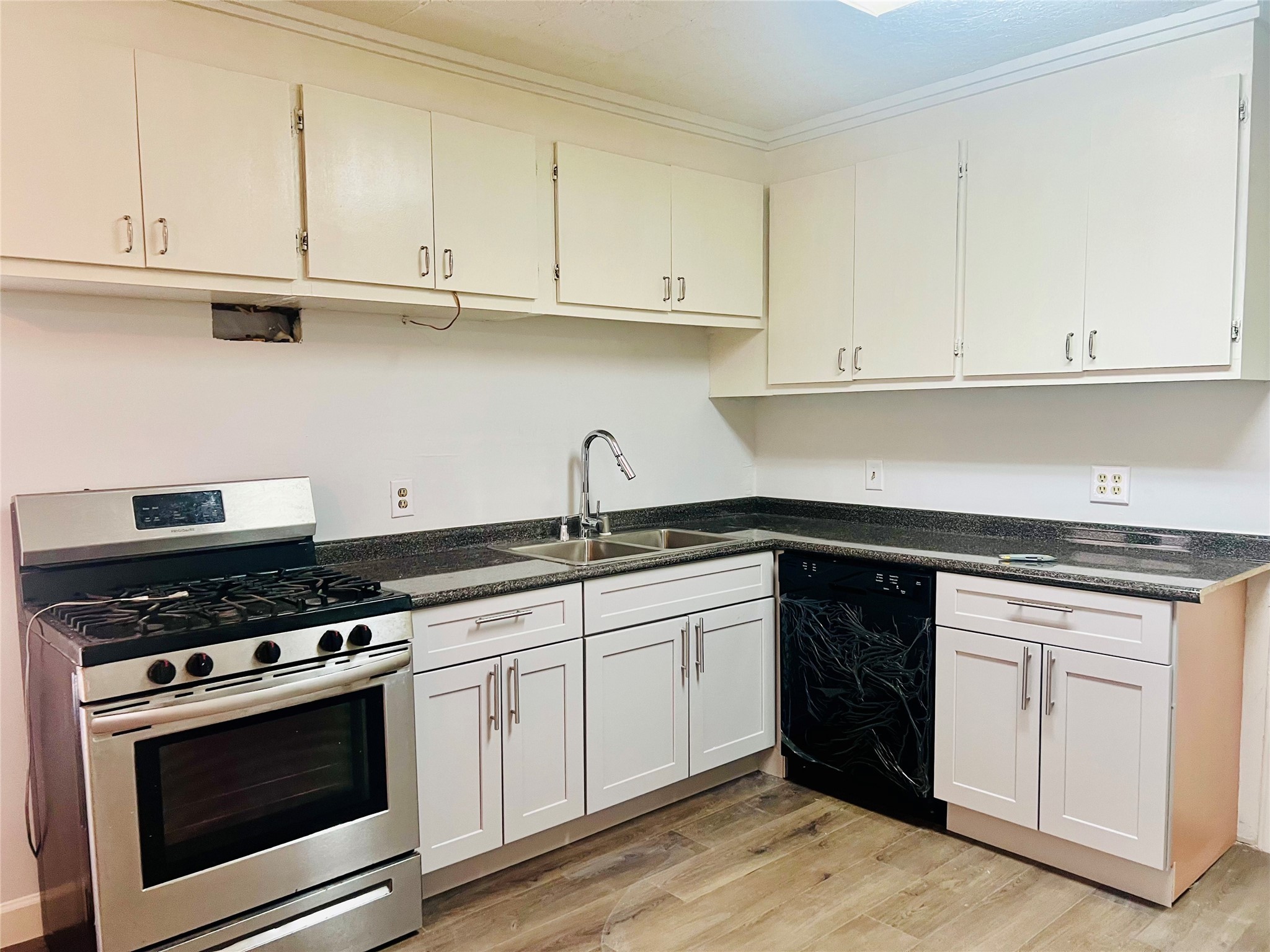 a kitchen with stainless steel appliances granite countertop a stove and white cabinets